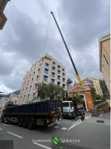 Une grue chargeant de la terre et des végétaux sur un toit