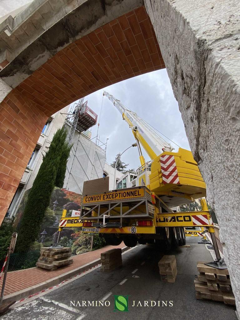 Une grue chargeant de la terre et des végétaux sur un toit